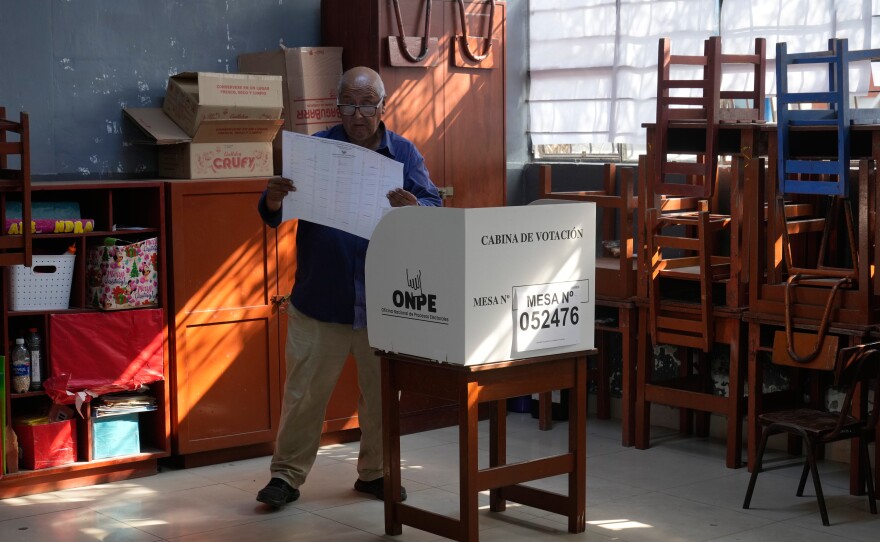A voter looks at a ballot before marking his candidates during general elections in Lima, Peru, on Sunday, April 12, 2026.