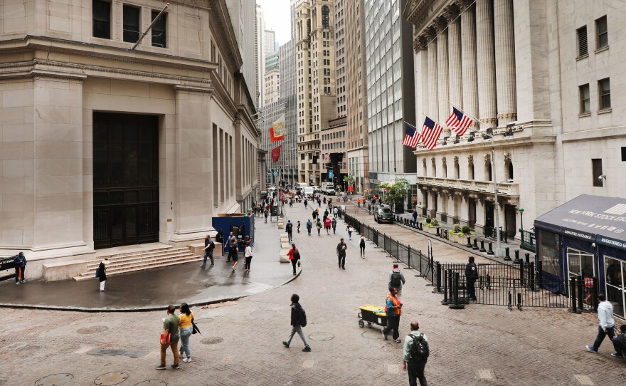 Investors are spending billions of dollars to align their portfolios with their personal values. But there's little agreement on what exactly qualifies — or disqualifies — an investment option from being marketed as sustainable. Above, pedestrians walk past the New York Stock Exchange on June 10.