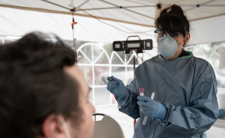 A healthcare worker wears a mask, gown and gloves in this undated photo. (Courtesy of Neighborhood Healthcare)