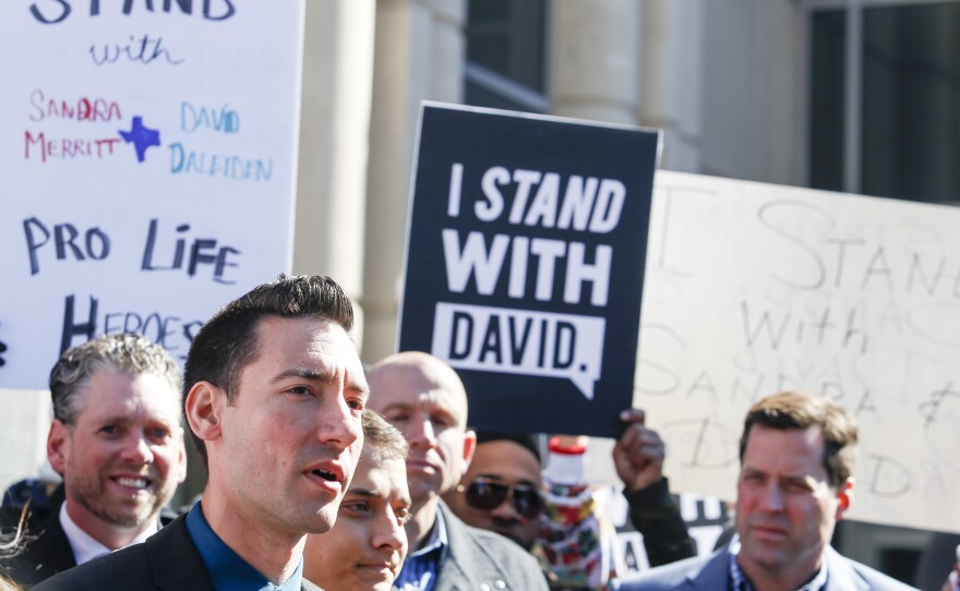David Daleiden (left foreground) speaks to the media after appearing in court at the Harris County Courthouse on February 4 in Houston, Texas. All charges against Daleiden and his fellow anti-abortion activist Sandra Merritt have been dropped.