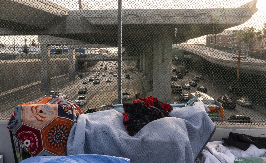 FILE - A homeless encampment is seen on a bridge over the CA-110 freeway, Wednesday, Dec. 15, 2021, in Los Angeles. The Los Angeles City Council has voted to ban homeless encampments within 500 feet of schools and daycare centers. The council voted Tuesday, Aug. 2, 2022, to broaden an existing ban on sleeping or camping near the facilities.