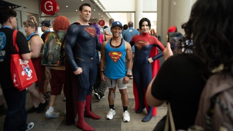 Dan Richard (left) and Carmen Estrada (right), cosplaying Superman and Superwoman, take a photo with Clark Pagauan on July 25, 2025.