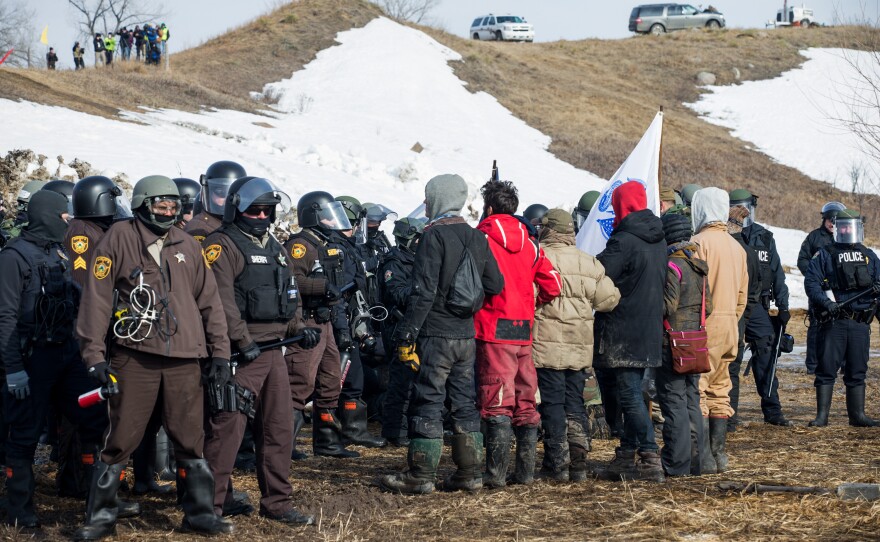 Protestors line up, arms linked, in peaceful protest as police enter the Oceti Sakowin camp on Thursday morning. All of the demonstrators were arrested.