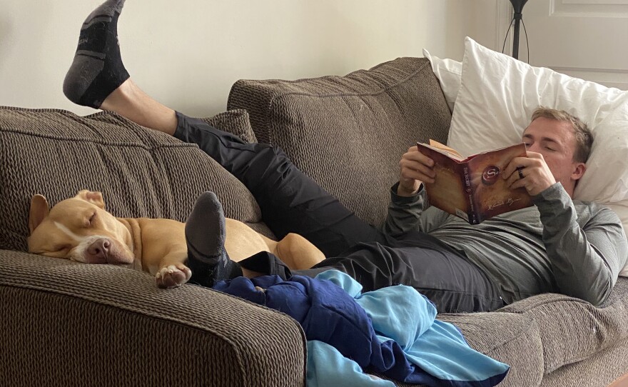 Nick recovers at home with his dog Teddy in September 2020. Unable to do much on his feet, Nick made a point to read as much as possible.
