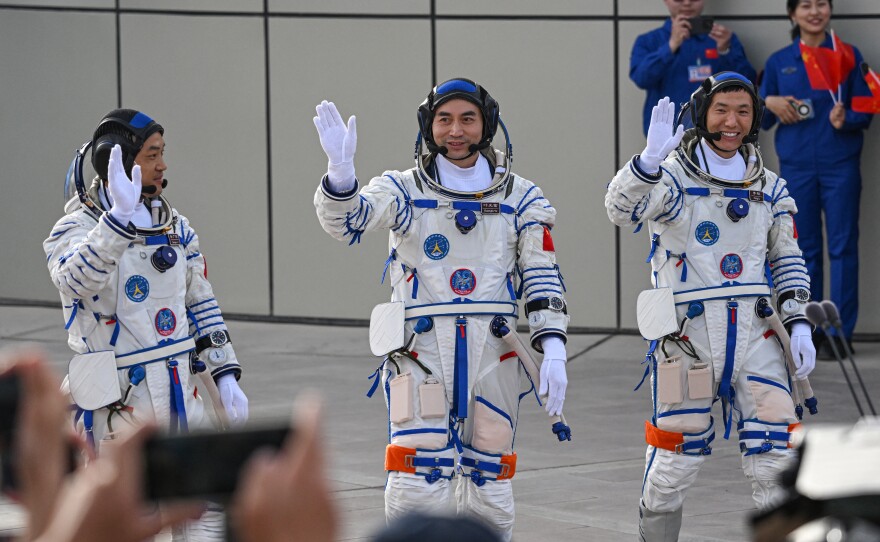 From left, astronauts for China's Shenzhou-18 space mission Li Guangsu, Ye Guangfu and Li Cong wave during a departure ceremony before boarding a bus to take them to the Shenzhou-18 spacecraft at the Jiuquan Satellite Launch Center in the Gobi desert in northwest China on Thursday.