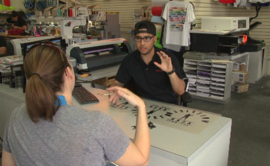 Christopher Avila working with a customer at T-Shirt Mart in Point Loma, March 11, 2015.