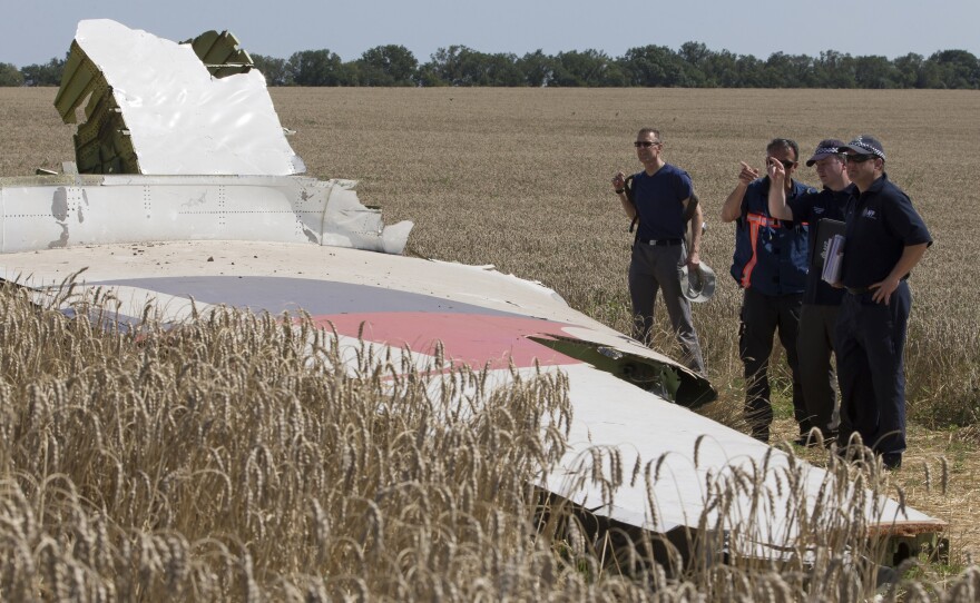 Australian and Dutch investigators examine a piece of the downed Malaysia Airlines Flight 17 plane, in eastern Ukraine's Donetsk region in August 2014.