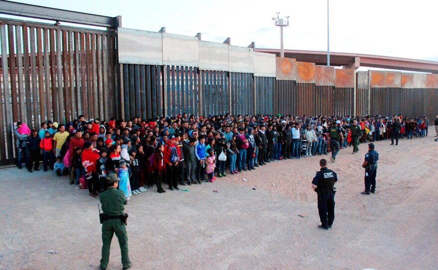 This May 29, 2019 photo released by U.S. Customs and Border Protection (CBP) shows some of 1,036 migrants who crossed the U.S.-Mexico border in El Paso, Texas, the largest that the Border Patrol says it has ever encountered.