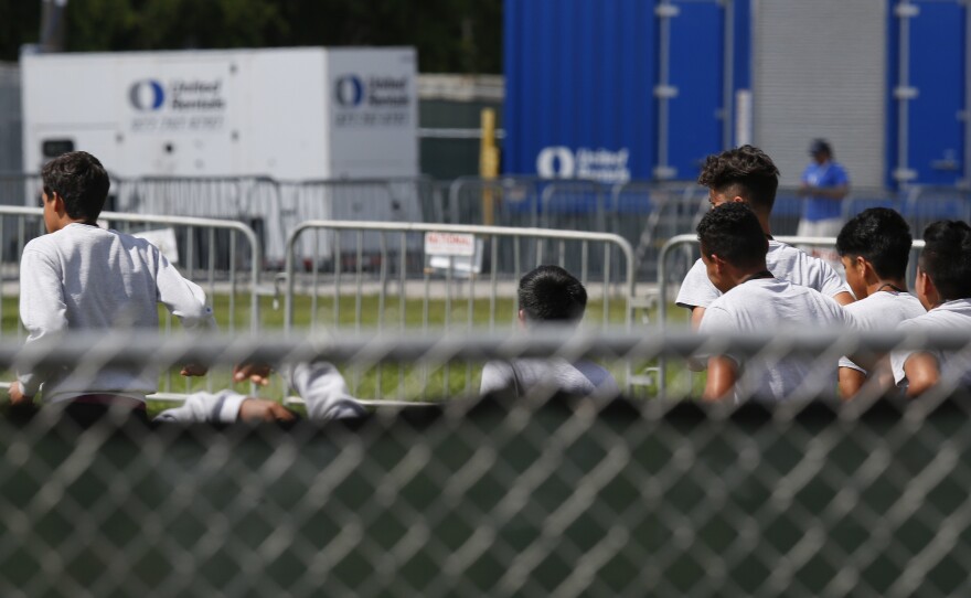 Migrant children run around a track outside at the Homestead Temporary Shelter for Unaccompanied Children in Homestead, Fla. Shelters that house these children are reaching capacity and the federal government is now working to speed releases to sponsors.