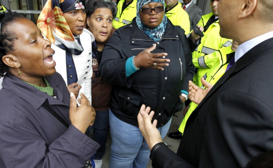 Newark Mayor Cory Booker, right, talks to community organizers after announcement of the Newark Public School chief in May. The organizers asked the mayor why the community wasn't invited to participate in the selection process.