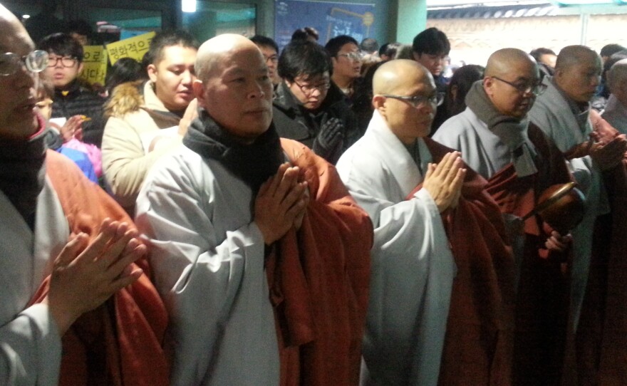 Monks form a human barricade outside the entrance to Seoul's Jogye Temple as police prepared to raid it to arrest a labor leader seeking refuge inside. The raid was postponed Wednesday.