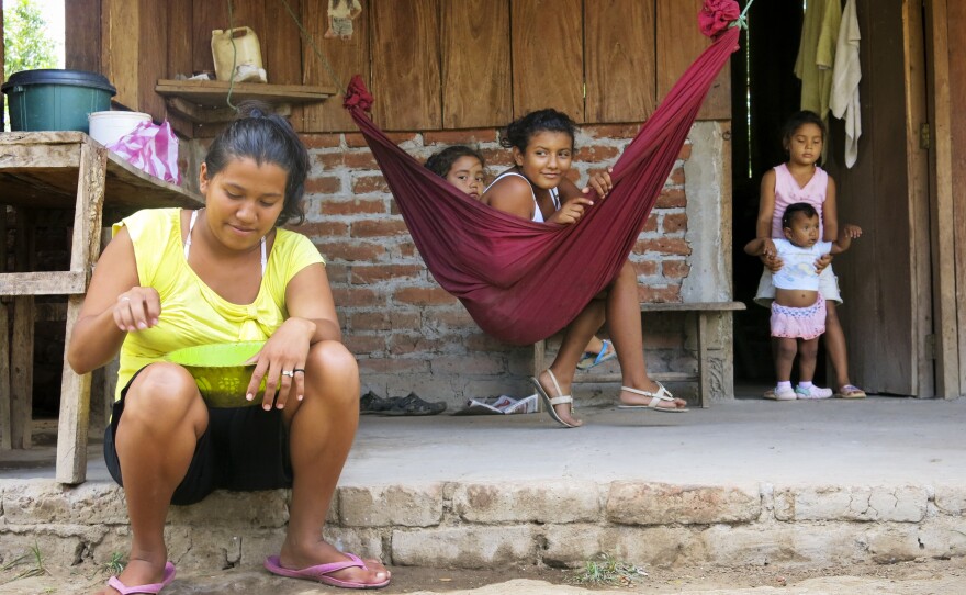 Ligda Bol, 19 years old, sits in front of her small farm. Her house, near the Brito River, is in the path of the proposed canal. Her family hasn't been told if she'll be forced to move, when a decision will be made or how she will be compensated for her farm.