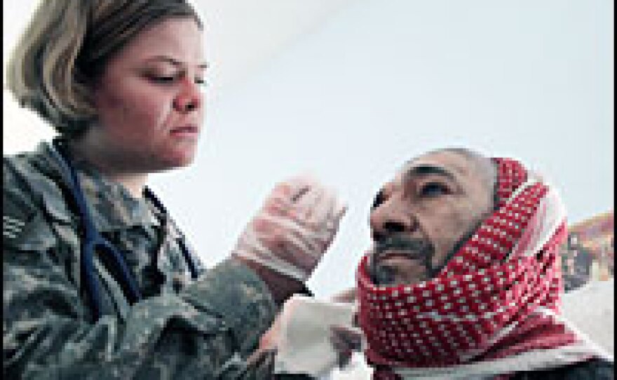 A medic with the U.S. Army's 82nd Airborne Division treats the wound of an Iraqi man in a temporary clinic in Baghdad's Sadr City in March 2007.