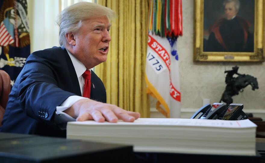 President Trump prepares to sign the tax legislation in the Oval Office on Dec. 22, 2017. The GOP tax cut did not pay for itself, as promised, nor did it deliver a sustained boost to economic growth.