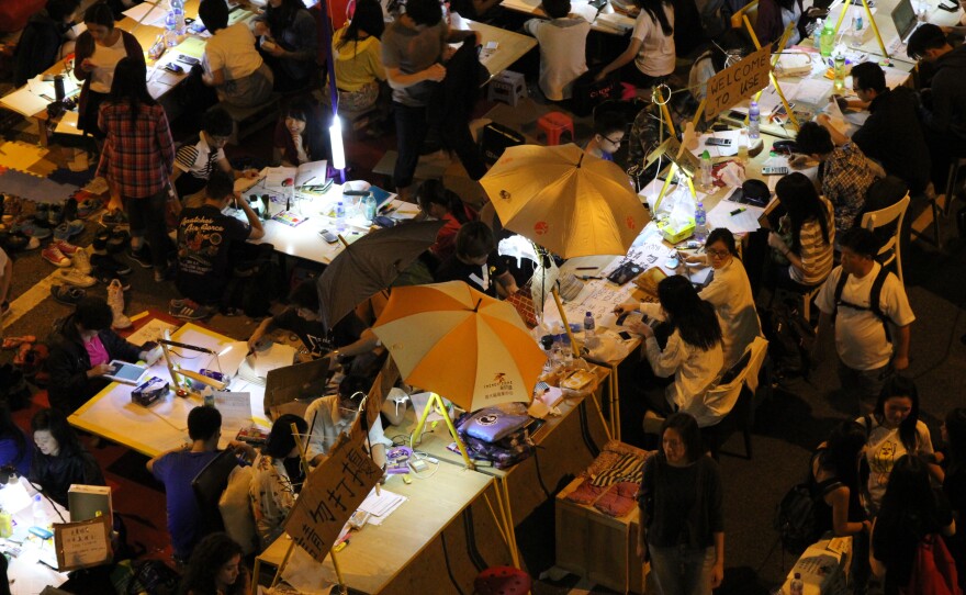 Student demonstrators don't want to fall behind on their studies, so volunteers built them an outdoor study hall. Some of the desks are built into the concrete highway divider.