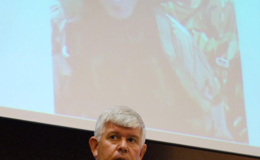 Retired Army Maj. Gen. Mark Graham speaks at a PTSD and brain injury conference at Fort Campbell, Ky., in 2012. The slide behind him shows his sons Kevin, who died from suicide, and Jeff, who died in combat in Iraq.