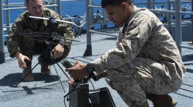 Setting up a portable communication array on board a ship.