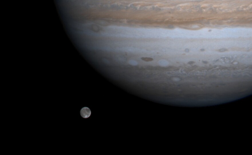 The solar system's largest moon, Ganymede, is pictured with Jupiter in a photo by NASA's Cassini spacecraft on Dec. 3, 2000. NASA's Juno mission got close to Ganymede on Monday.