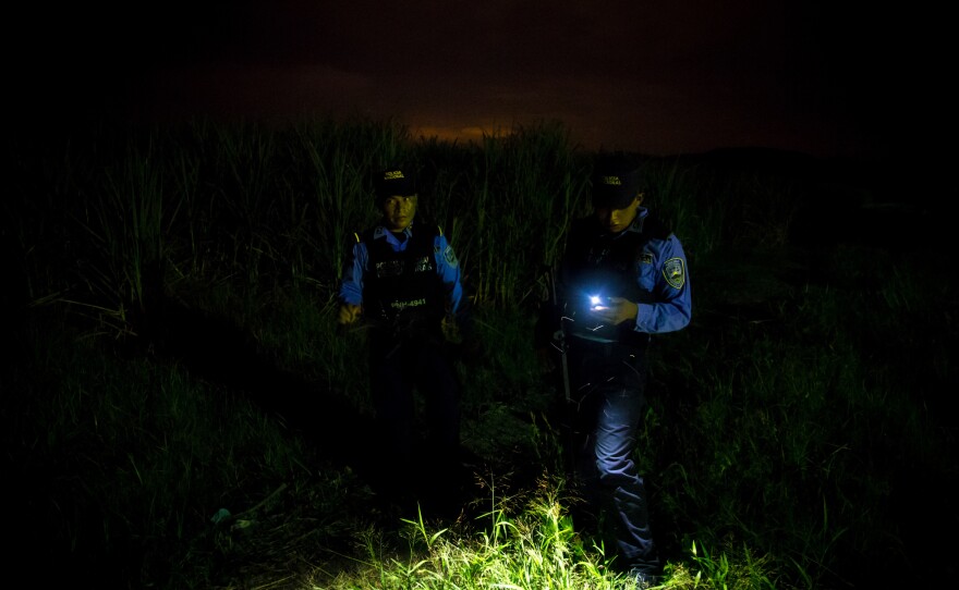 Police stand before a site where bodies are dumped in San Pedro Sula, investigating the latest corpse. "It was another body in a potato sack, contorted to fit in the bag," says Ayuso.<strong> </strong>