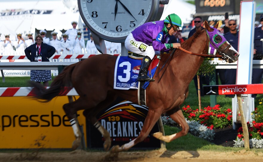California Chrome, ridden by Victor Espinoza, crosses the finish line to win the Preakness Stakes on May 17 in Baltimore.