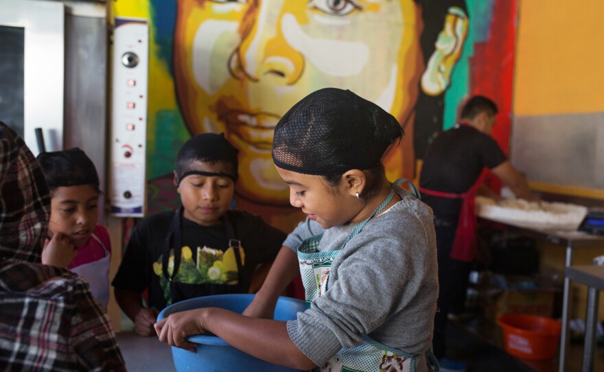 Fourth graders prep dough to bake during a cooking class. Los Patojos has grown into a community center and school educating over 300 students.