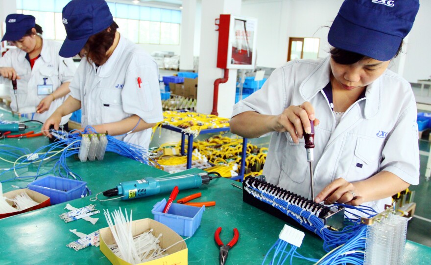 Workers assemble computers at a factory in Jiashan, east China's Zhejiang province.