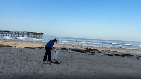 Vi Nguyen picks up trash on Pacific Beach in this undated photo. Nguyen is a local pediatrician who has been picking up plastic along San Diego's coastline for the past seven years.