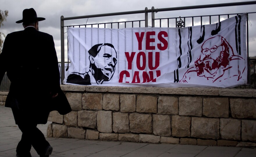 An Israeli man walks past a banner in 2013 depicting President Obama and Jonathan Pollard, a Jewish-American who was jailed in 1985 on charges of spying on behalf of Israel. Israelis have repeatedly called for Pollard's release. He is expected to be freed from a North Carolina prison on Friday.