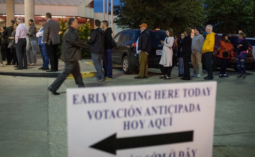 People wait in line to vote at a polling place on the first day of early voting on Oct. 22 in Houston. Texas Attorney General Ken Paxton has been aggressively prosecuting people for voting violations, which critics argue is designed to intimidate non-white voters.