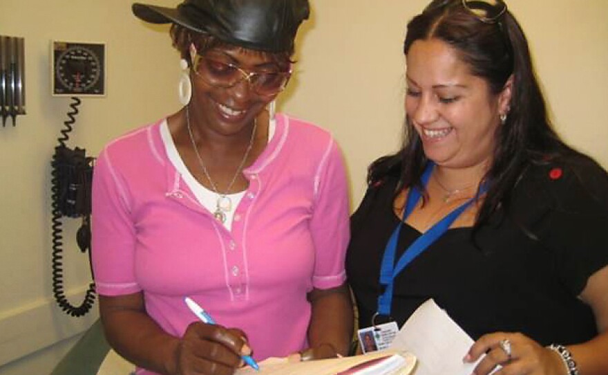 Juanita Alvarado (right), a community health worker at the Transitions Clinic in San Francisco, helps a patient.