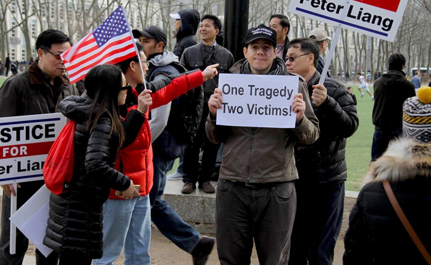 A man holds “One Tragedy, Two Victims” sign at the Feb. 20, 2016 protest in support of Peter Liang at Cadman Plaza in Brooklyn, N.Y.