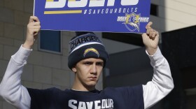 San Diego Chargers fan Richard Farley shows his feelings about keeping the NFL team in San Diego as he holds a sign that reads, "Save Our Bolts." Farley is outside the hotel where NFL owners are meeting in Houston to discuss possible relocation to Los Angeles, Jan. 12, 2016.
