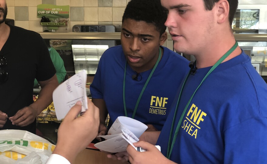 Demetrius Vitalich and Shea Harbour look at a sandwich order, June 27, 2018.