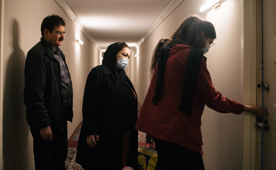 Kamila Noori enters the apartment where she will live with her husband Mohibullah Mohib, at left, and two of their daughters.