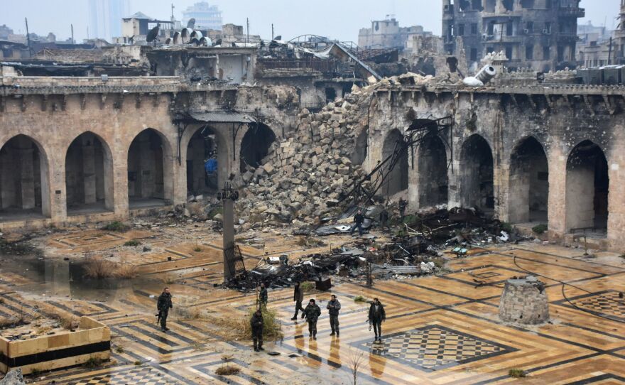Syrian pro-government forces walk in the ancient Umayyad mosque in the old city of Aleppo on Tuesday, after they captured the area. After weeks of heavy fighting, regime forces were poised to take full control of Aleppo, dealing the biggest blow to Syria's rebellion in more than five years of civil war.
