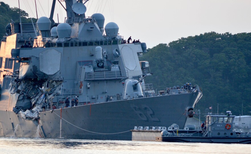 The guided missile destroyer USS Fitzgerald returns to Yokosuka after its collision Saturday. Authorities say the ship's flooding "has been stabilized," though seven sailors remain unaccounted for.