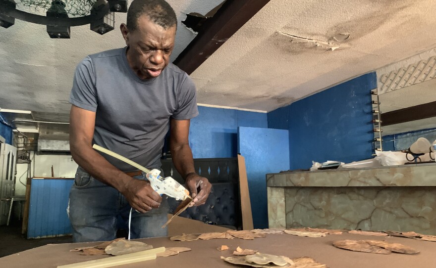 Marvin Weeks glues oak leaves for his newest body of work.