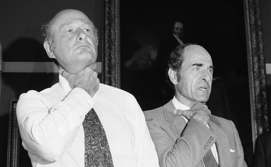 At New York City Hall in 1981, Heimlich (right) and Mayor Edward Koch demonstrate how a choking victim should signal for help.