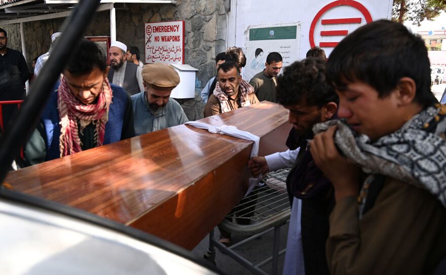 Relatives load the coffin of a victim of the Kabul attack into a car Friday at a hospital run by the Italian nongovernmental organization Emergency.