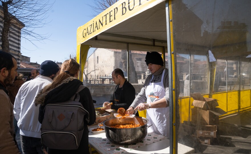 A tent outside the restaurant serves free food to people who need a meal.