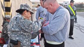 Capt. Karla Frey helps a soldier pin on his race bib at the 5K warrior run.


