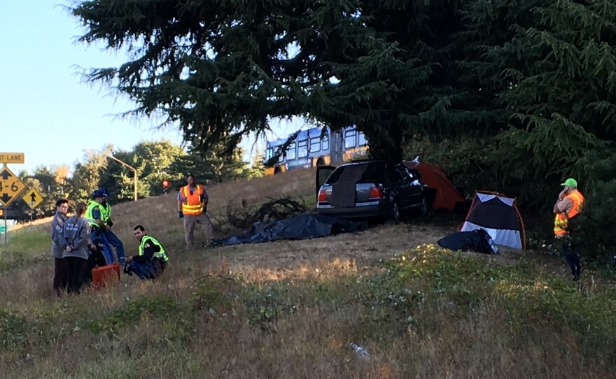 Officials inspect the scene at the Seattle homeless camp known as "the Jungle," where a car ran off the road and resulted in the death of a young man who was in his tent.