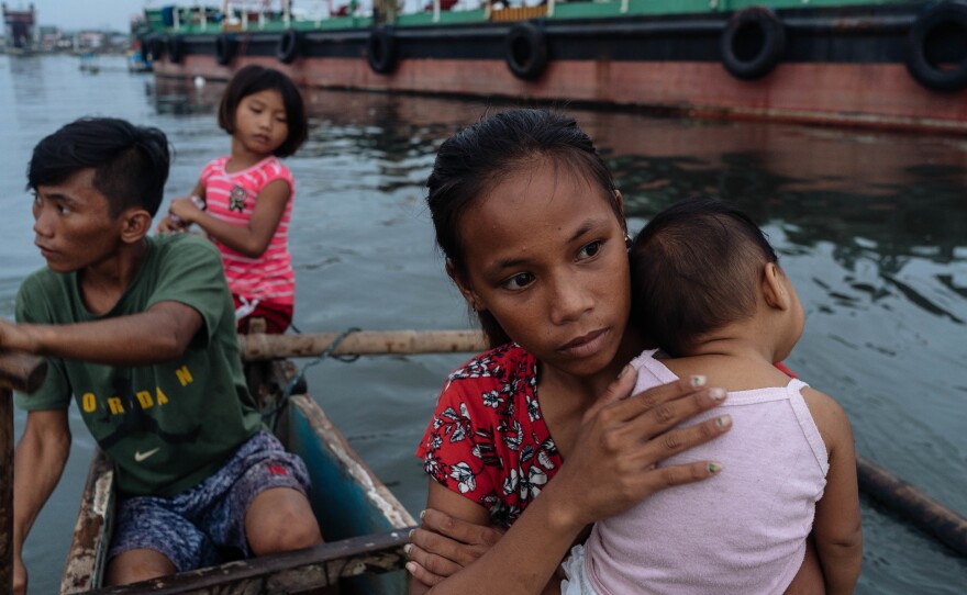 Joan Garcia (right) and her baby take a boat ride home. Garcia says she's embarrassed to play kids' games now that she's a mother — but admits "sometimes I still play tag in the water with my brothers."