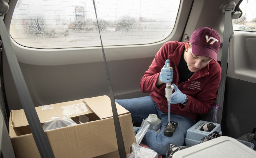 Maggie Carolan, part of Virginia Tech professor Marc Edwards' team, collects water samples and processes them in the back of their van in Flint.
