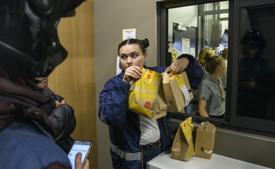 Customers and delivery couriers line up at a newly reopened McDonald's in Kyiv on Tuesday. Three locations in Kyiv reopened for the first time since Russia's invasion on Feb. 24.