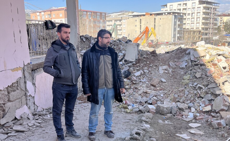 Ali Kafadenk (left) and his brother Abdullah look at the rubble of Ali's apartment building in Islahiye, Turkey. The building was reduced to rubble in the Feb. 6 earthquake that hit Turkey and Syria.
