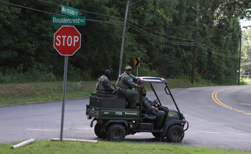 Law enforcement officers drive past a memorial for Manuel "Tortuguita" Terán, an activist killed by law enforcement, near the site of Atlanta Public Safety Training Center that protesters refer to as "Cop City" in Atlanta, Georgia, U.S., June 23, 2023.