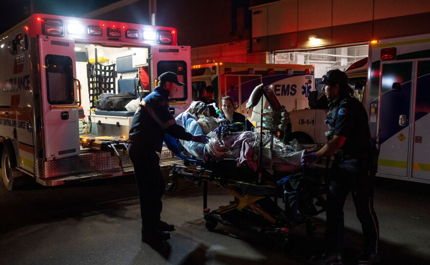 Paramedics load an injured person into an ambulance at the Wainwright Health center after a fire at Canadian Forces Base Wainwright, outside of Wainwright, Alberta Saturday, Oct. 17, 2026.