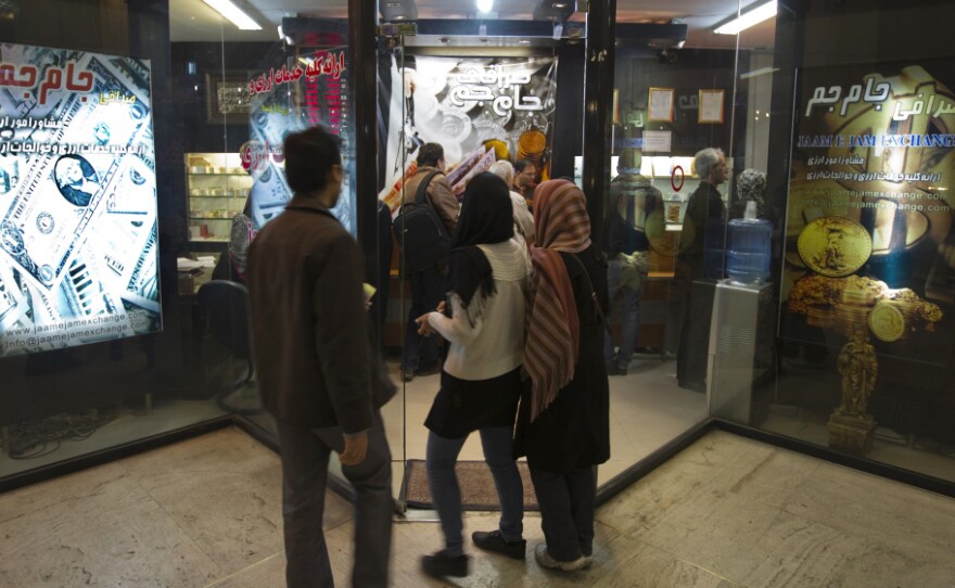 Iranians wait to enter a currency exchange shop in Tehran on Jan. 3. The Iranian rial fell to a record low against the dollar in early January after President Obama signed a bill imposing fresh sanctions on the country's central bank.
