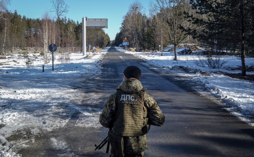 A member of the Ukrainian State Border Guard stands watch at the border crossing between Ukraine and Belarus on Saturday.